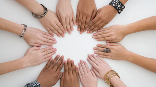 Teenage friends with hands placed in a circle